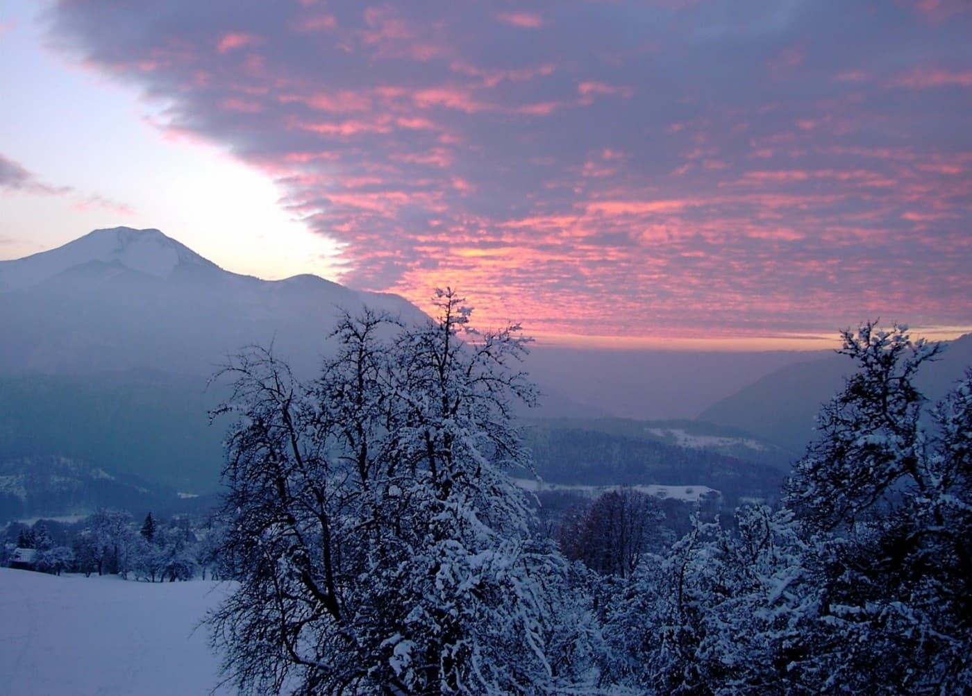 Coucher de soleil hivernal sur les sommets enneigés de Haute-Savoie.